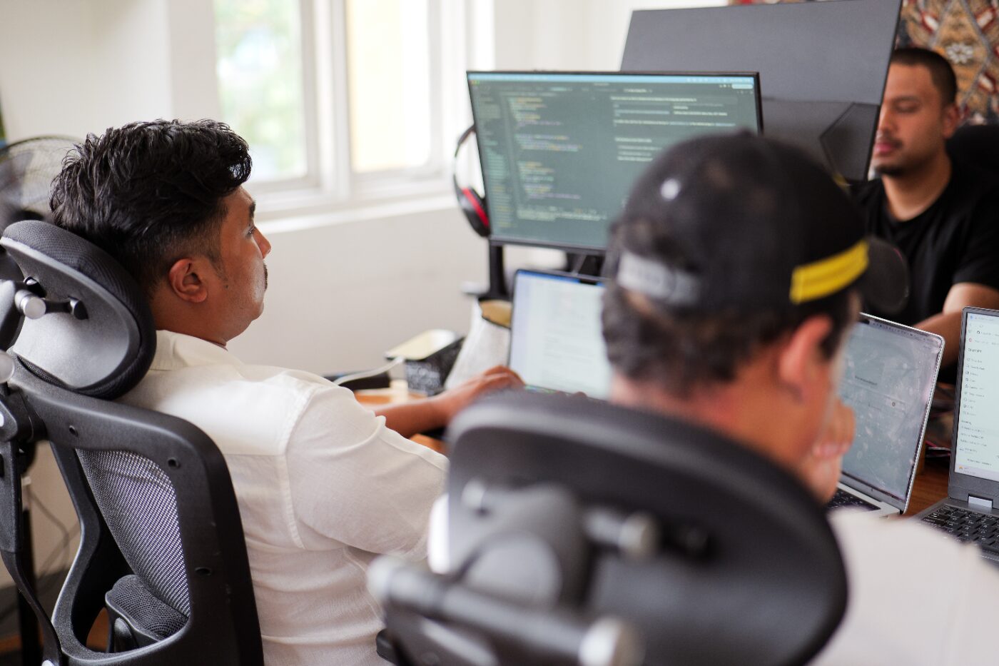 Engineers at a bank of code editors